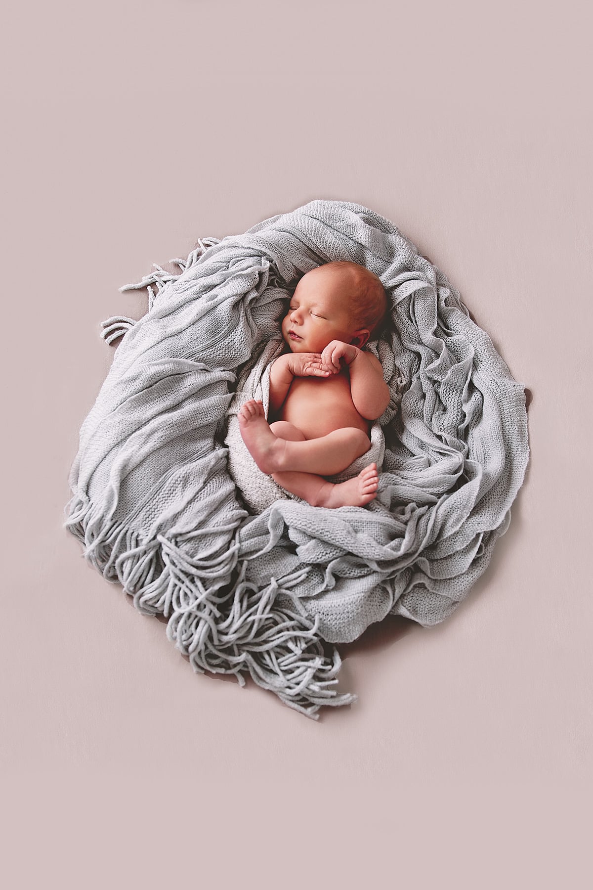 newborn in a blanket nest