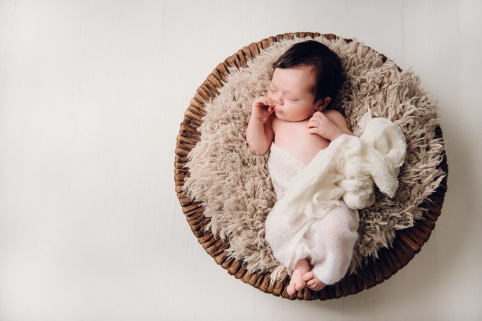 newborn girl in brown basket