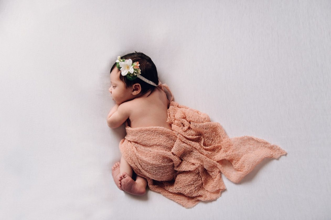 newborn girl in dusty pink wrap